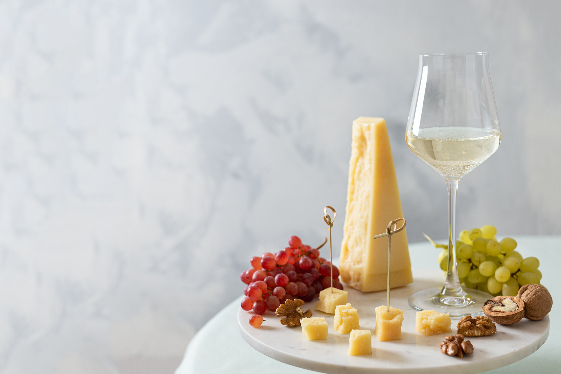 Dish with appetisers and a glass of wine to pair with Parmigiano Reggiano for an aperitif