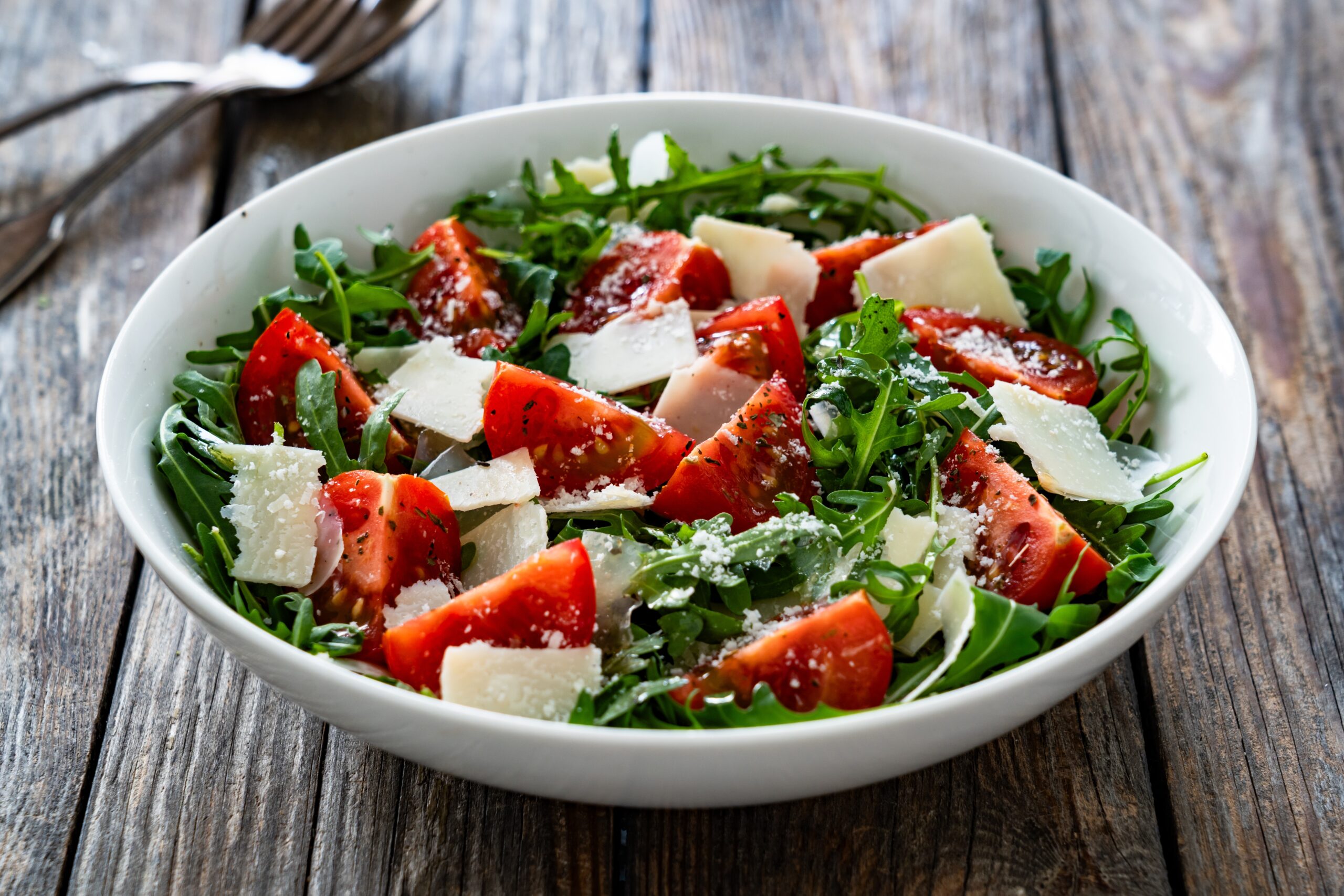 un'insalata con parmigiano, rucola e pomodorini